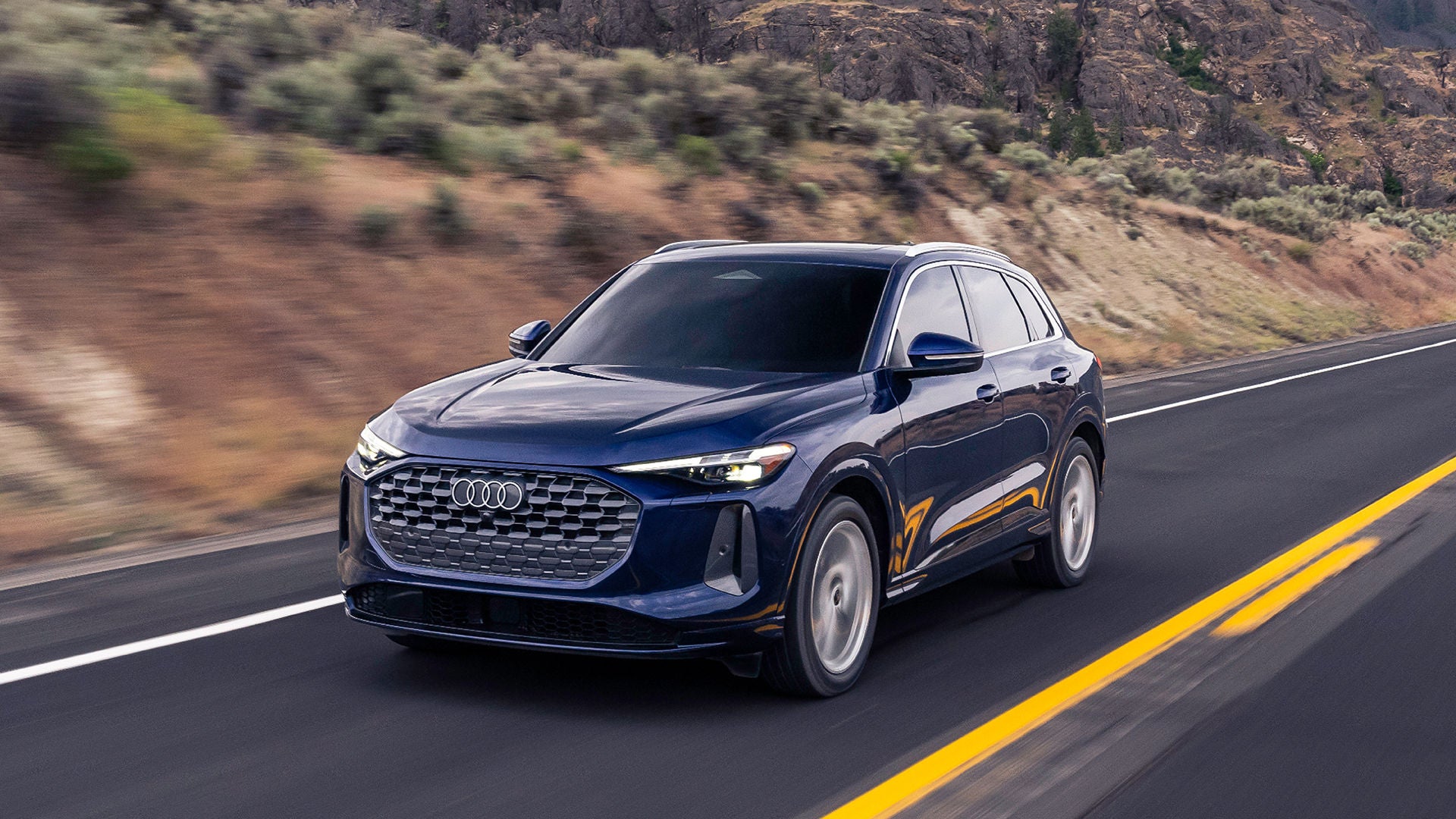 Drivers side profile view of an Audi Q5 driving.